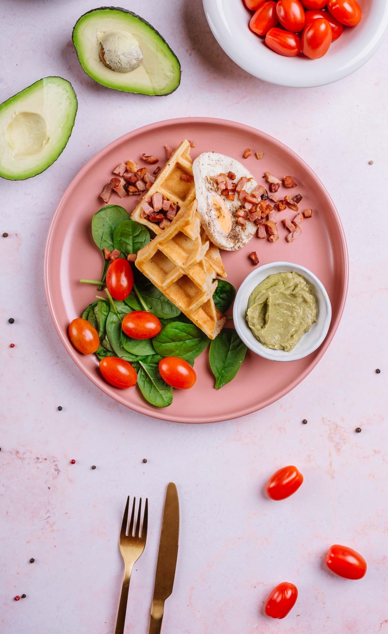 Gofry orkiszowe z jajkiem sadzonym, bekonem i guacamole, świeże warzywa