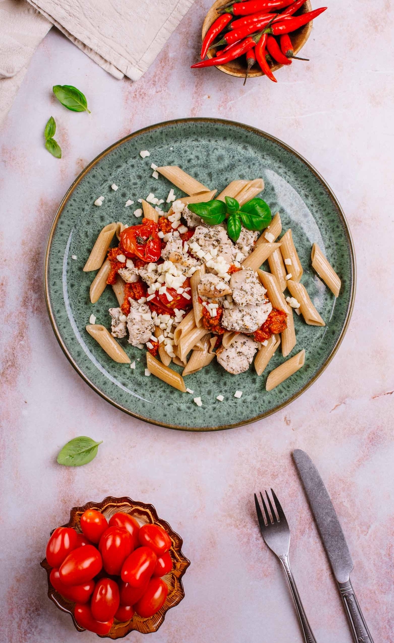 Pełnoziarniste penne z pikantnym sosem arrabbiata, kawałkami kurczaka i mozzarellą, pieczone pomidorki