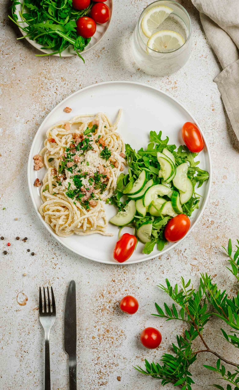Świeże spaghetti alla carbonara z boczkiem i parmezanem, chrupiąca sałatka