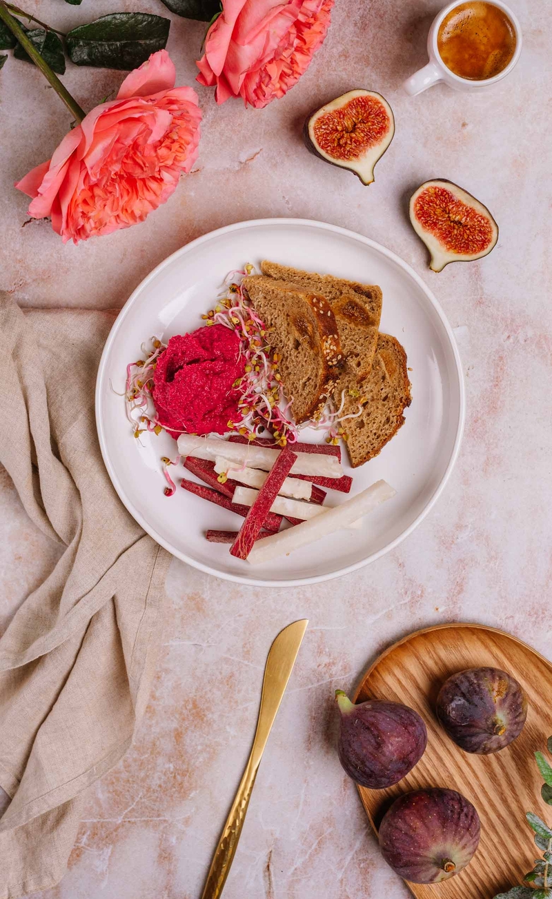 Hummus buraczkowy, chleb z figą i daktylami, słupki warzyw: burak, rzepa