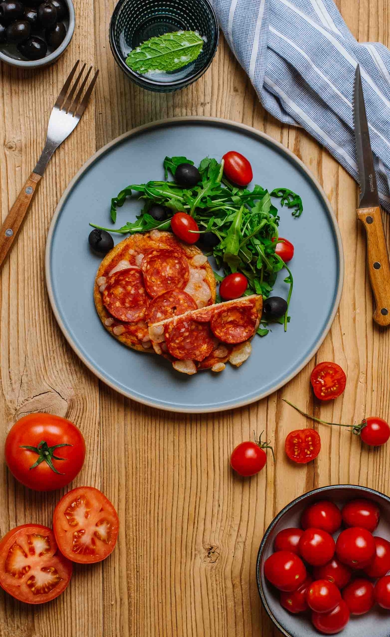 Keto mini pizza z sosem pomidorowym, salami i mozzarellą, świeże warzywa