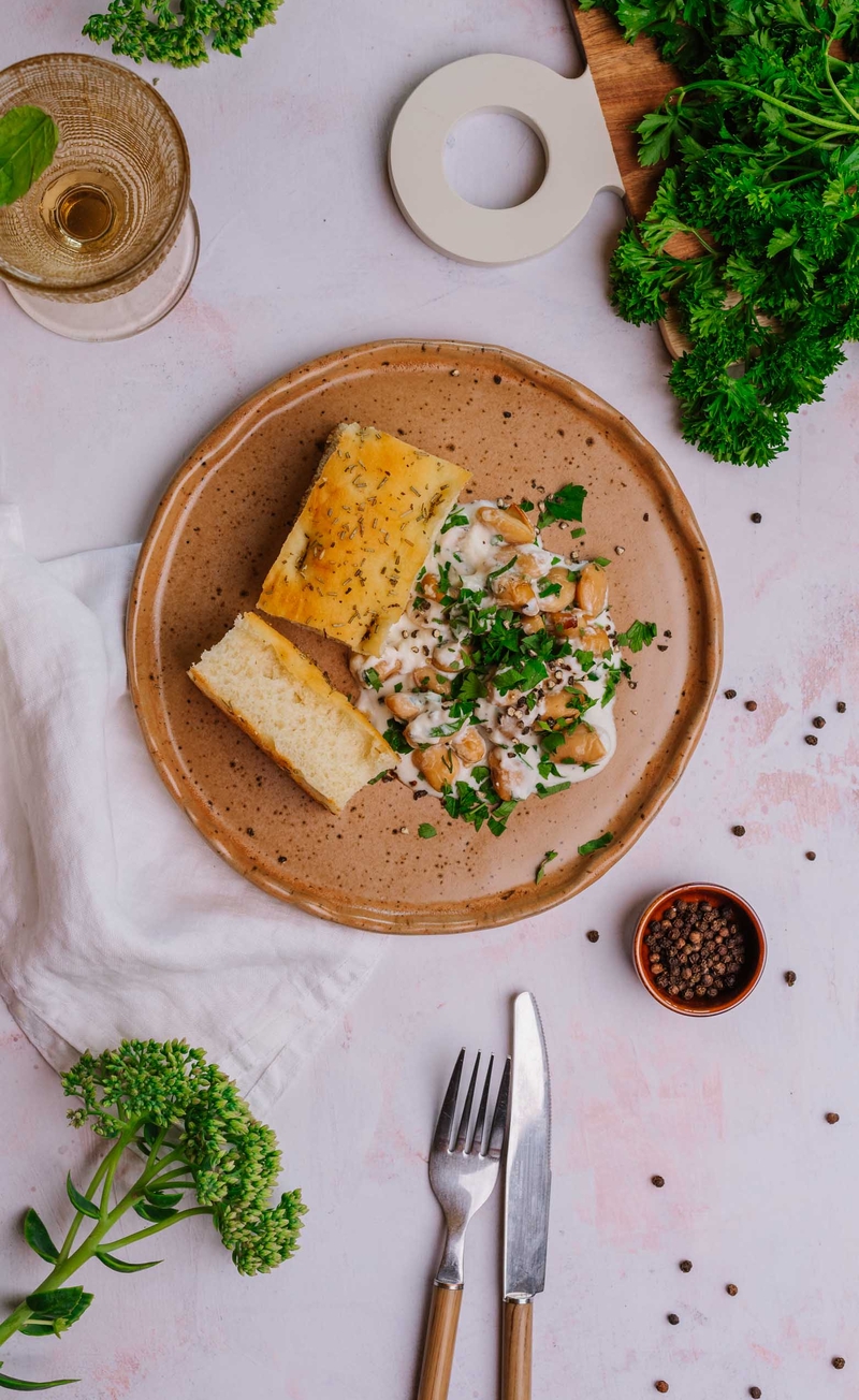 Fasola Jaś w sosie a'la cacio e pepe z Parmigiano Reggiano i młotkowanym pieprzem z natką pietruszki, świeża focaccia