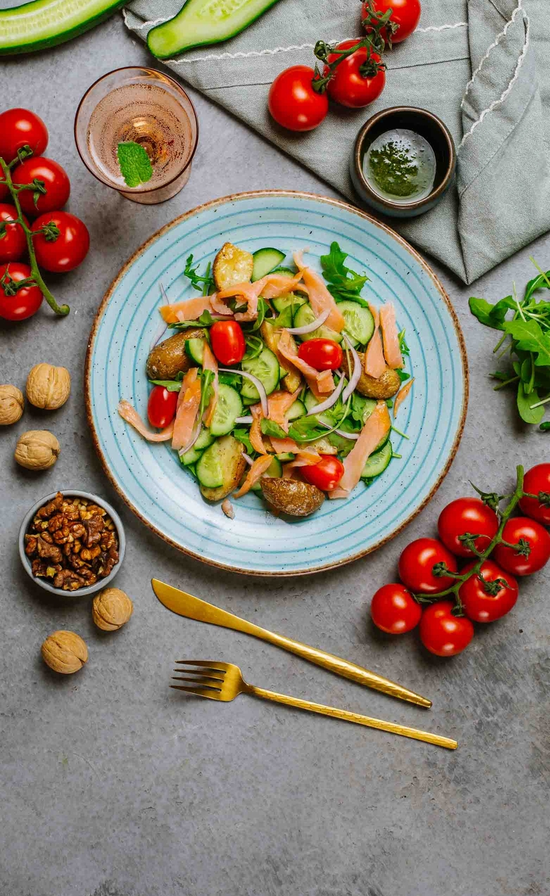 Sałatka z pieczonymi ziemniakami, wędzonym łososiem, rukolą i zielonym ogórkiem, pesto z orzechów włoskich i pestek dyni