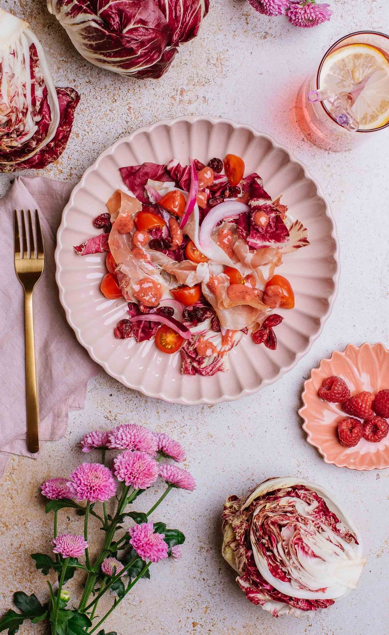 Sałatka z sałatą rzymską, radicchio, żurawiną, szynką parmeńską i czerwoną cebulą, malinowy dressing