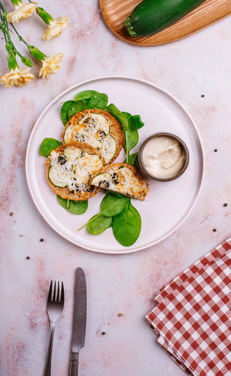 Mini pizza na spodzie kalafiorowym z serem cypryjskim, plastrami cukinii i oliwkami, sos aioli