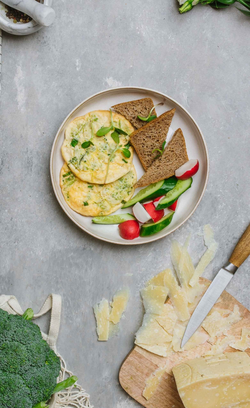 Omlet z serem żółtym, brokułami i szczypiorkiem, chleb razowy, świeże warzywa