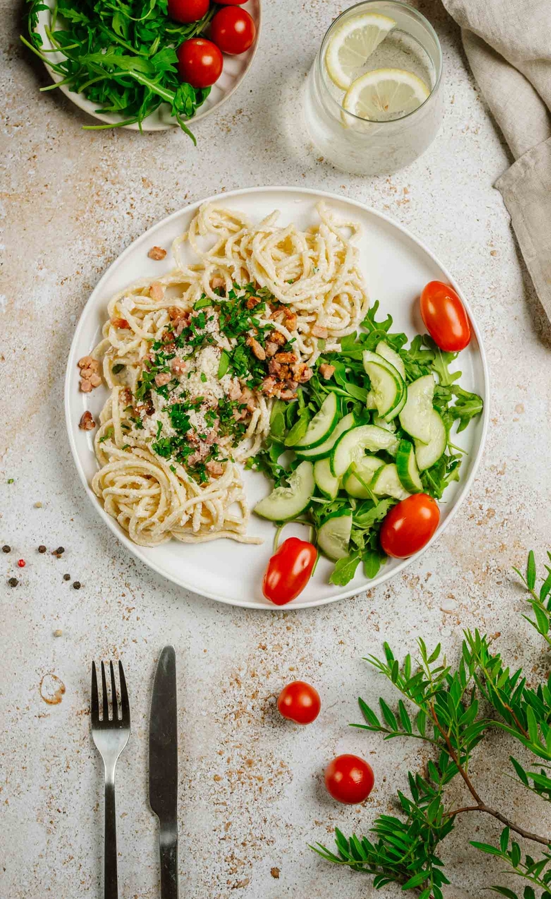 Świeże spaghetti alla carbonara z boczkiem i parmezanem, chrupiąca sałatka