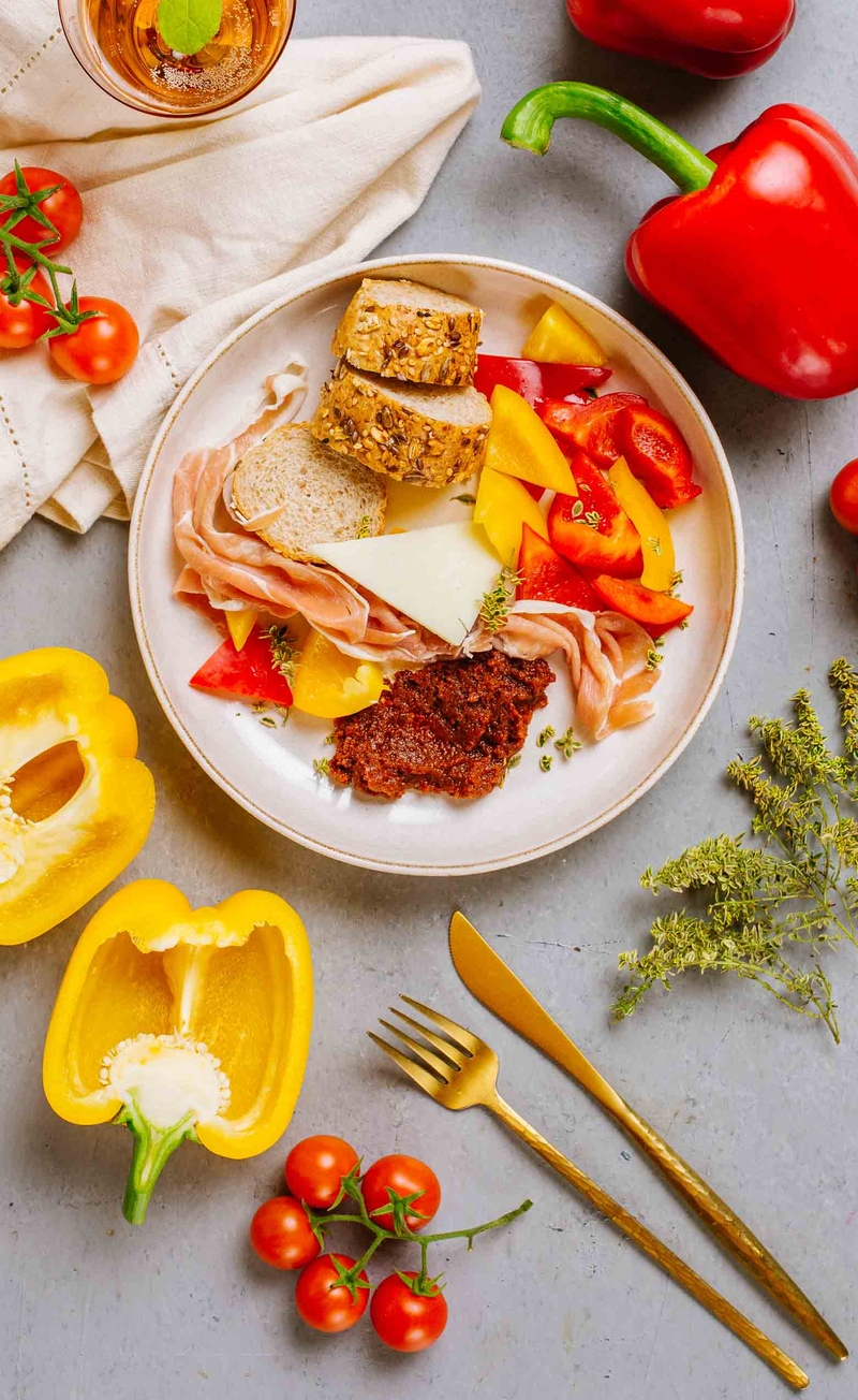 Hiszpańskie śniadanie: bagietka z pomidorami, serem Manchego i jamon serrano, papryka
