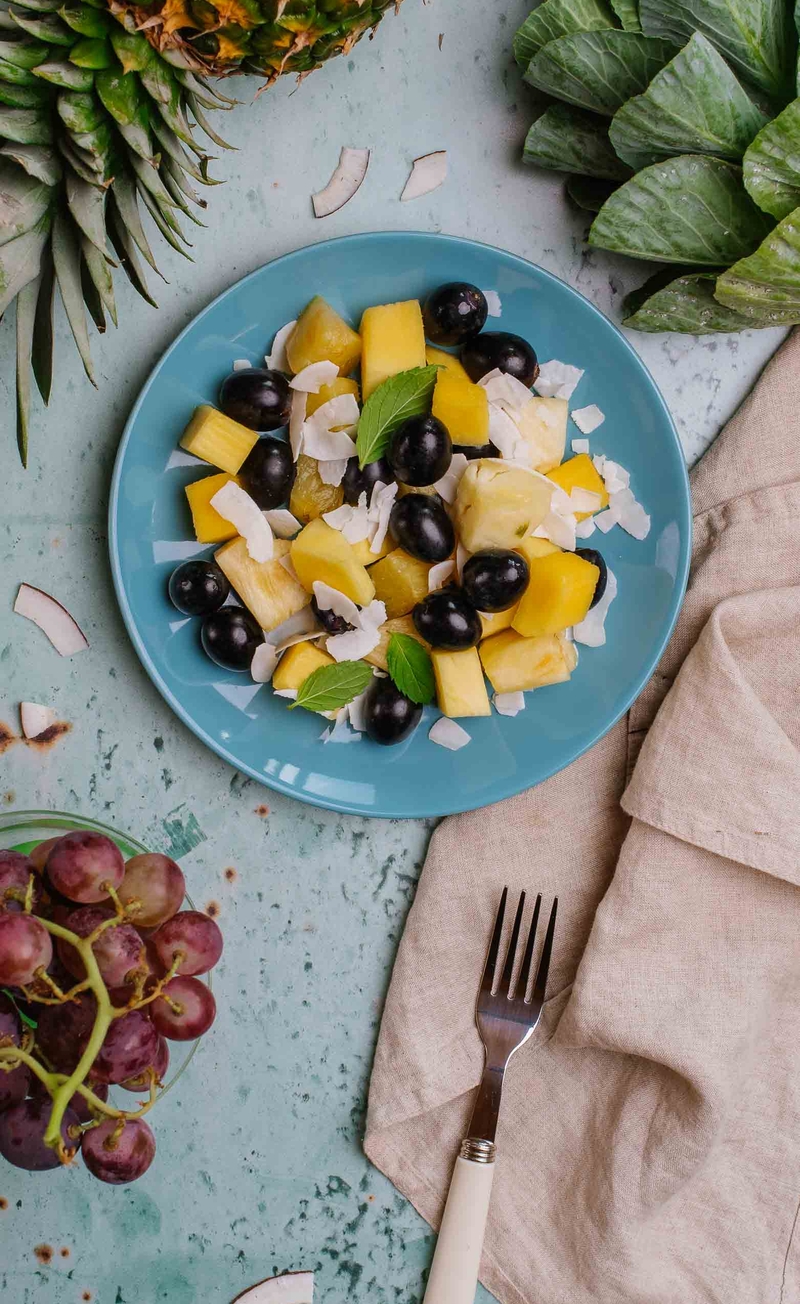 Sałatka owocowa z mango, ananasem, ciemnymi winogronami i plastrami kokosa