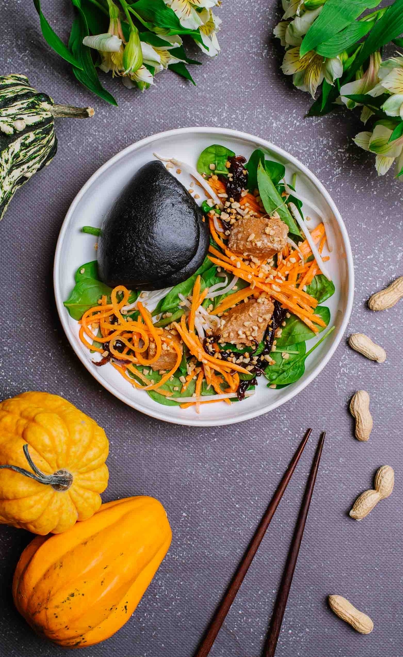 Czarna bułeczka bao z roślinnym łososiem teriyaki, piklowaną cebulą i chrupiącymi warzywami