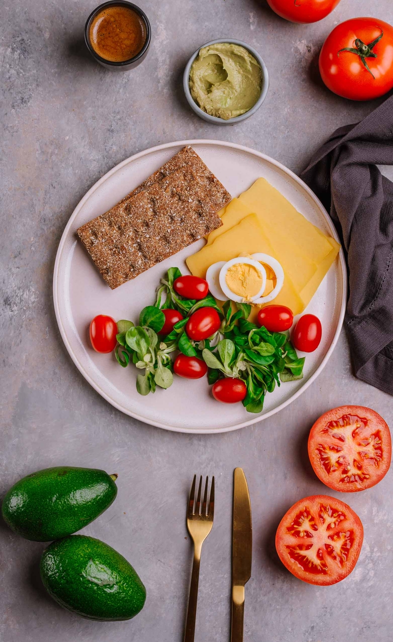 Jajko na twardo, pasta z awokado, ser cheddar, chrupkie pieczywo żytnie, świeże warzywa