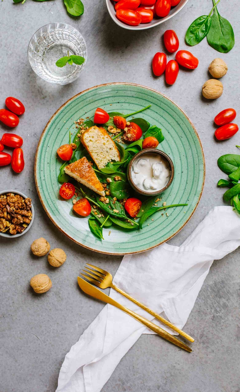 Keto chlebek śródziemnomorski, grecka pasta z oliwkami, listki szpinaku z pomidorkami i orzechami