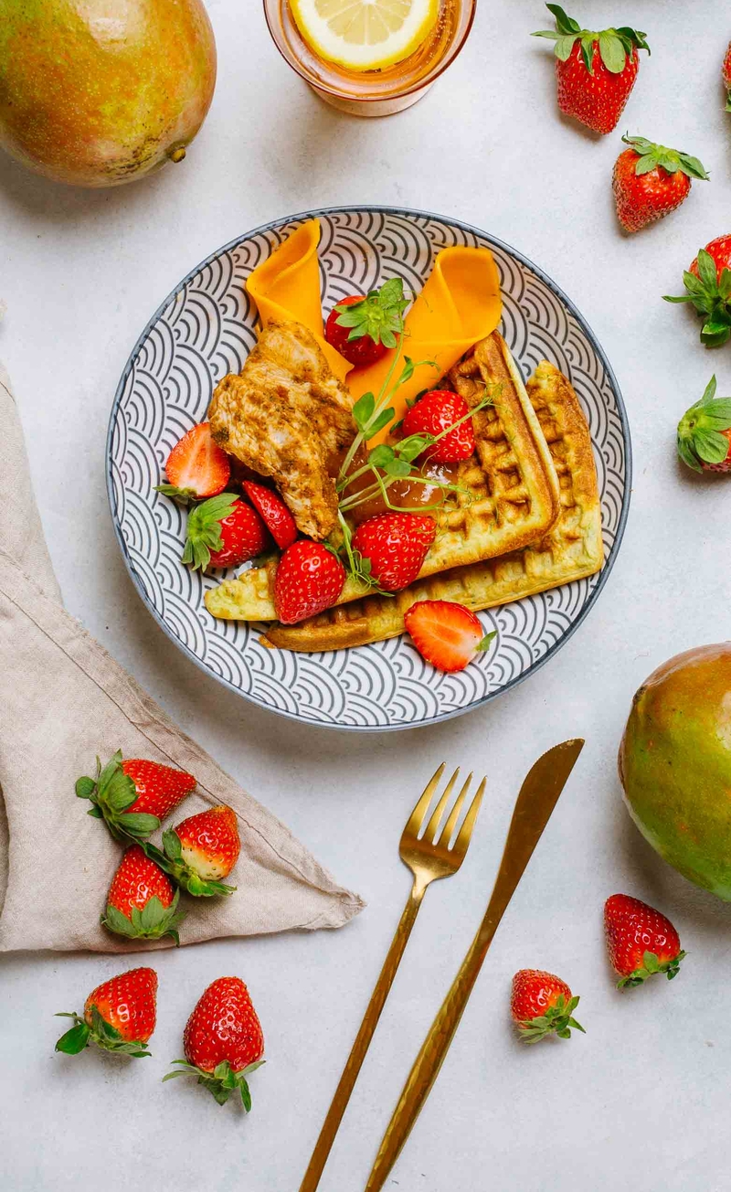 Gofry bazyliowe z plastrami indyka, serem mimolette i słodko-ostrym chutney z mango, truskawki