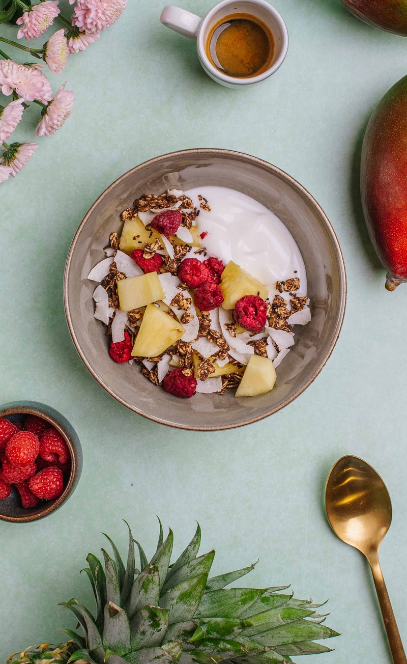 Czekoladowa granola z chipsami kokosowymi, liofilizowanymi malinami, jogurt kokosowy, ananas, mango
