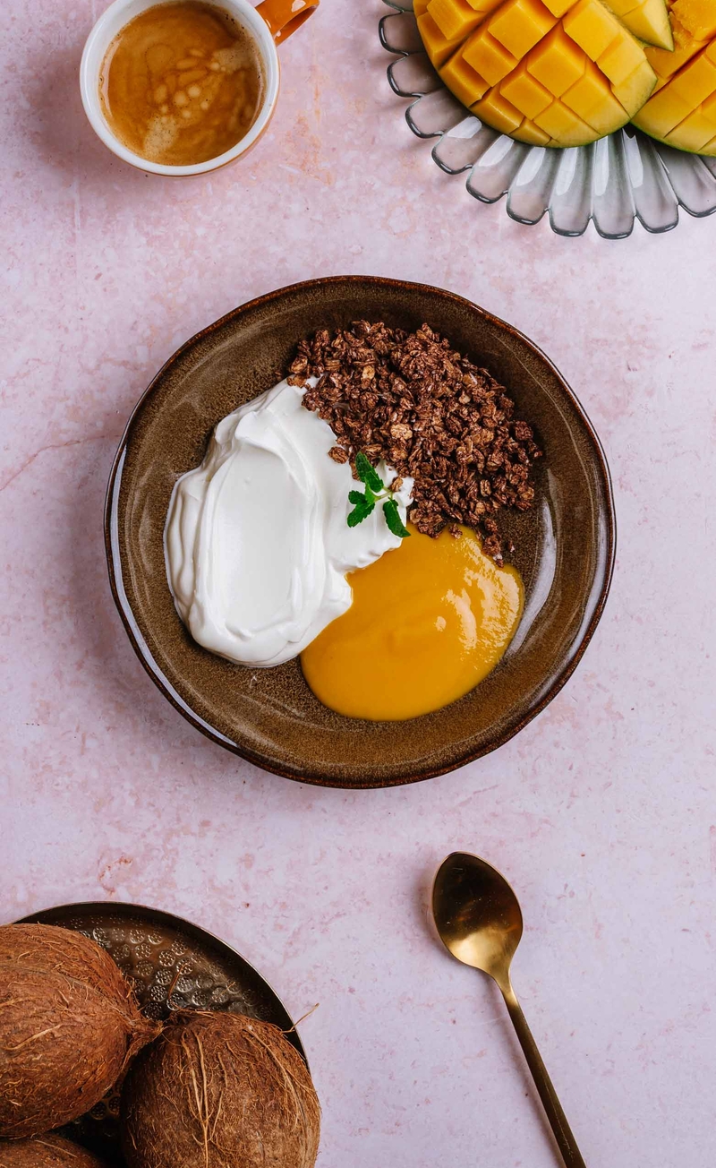 Kakaowa granola z wiórkami kokosa, jogurt grecki, mus mango