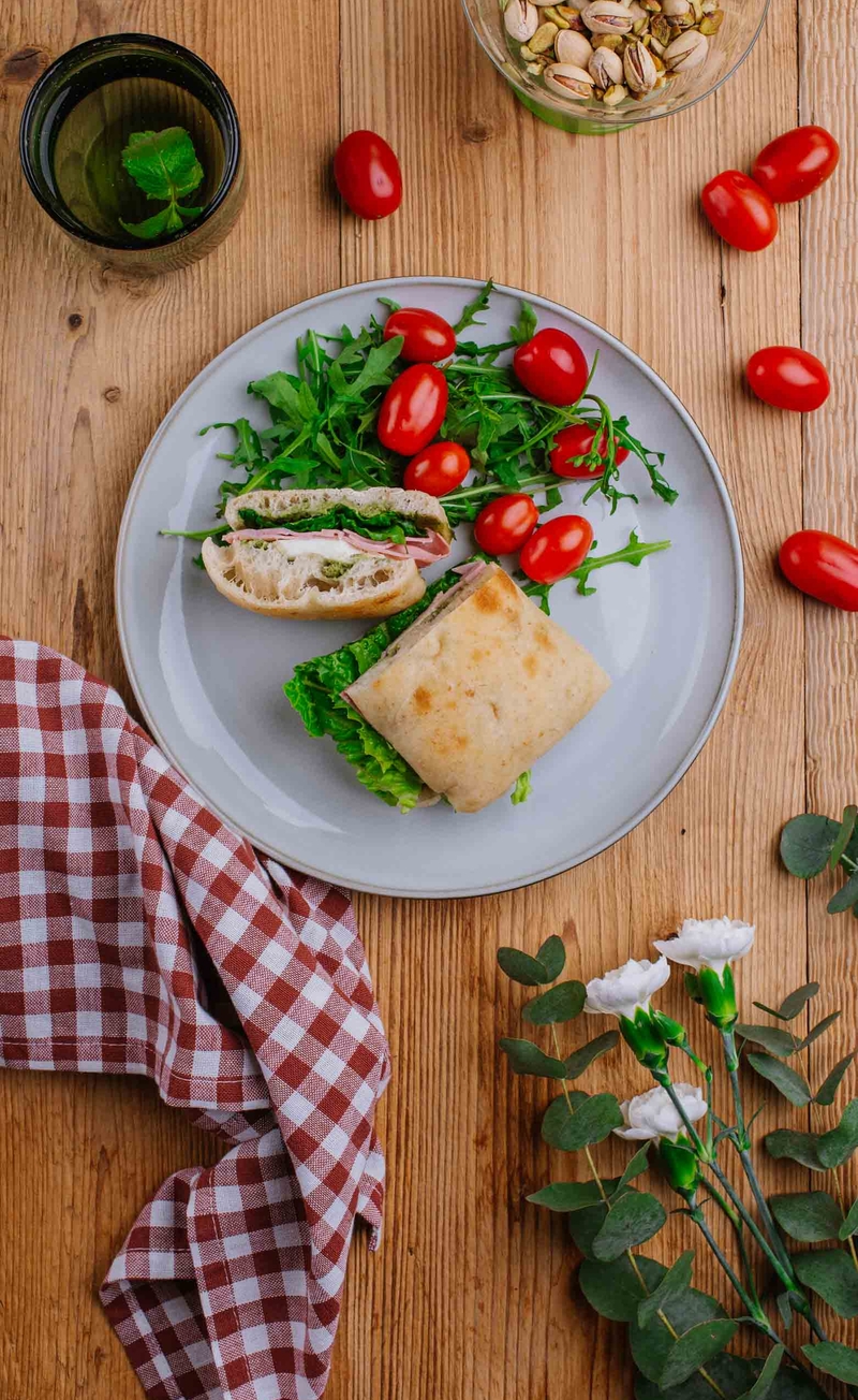 Schiacciata z pesto pistacjowym, sałatą rzymską, mozzarellą i prosciutto cotto, pomidorki