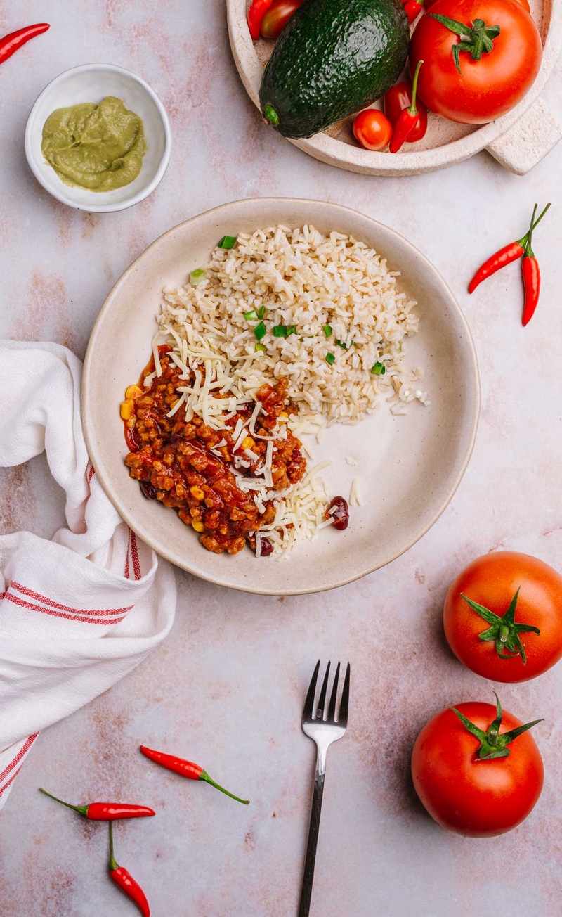 Chilli sin carne z roślinnym mięsem, czerwoną fasolą i kukurydzą, brązowy ryż, mus z awokado