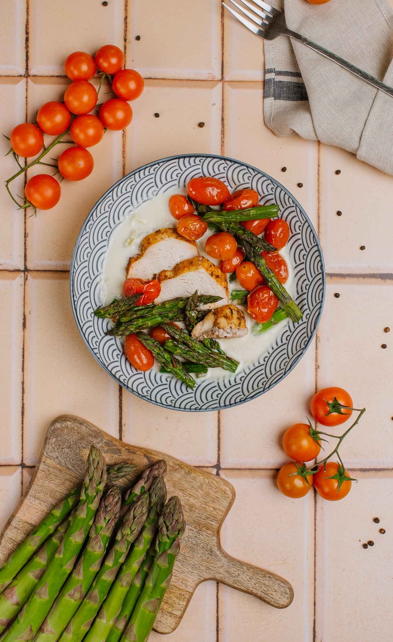 Keto Chicken primavera - kurczak w sosie serowym ze szparagami i porem, pomidorki pieczone w oliwie