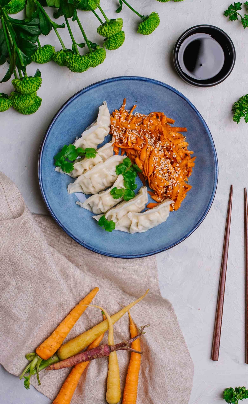 Pierożki gyoza z mięsem, azjatycka marynowana marchewka z sezamem, sos sojowo-miodowy