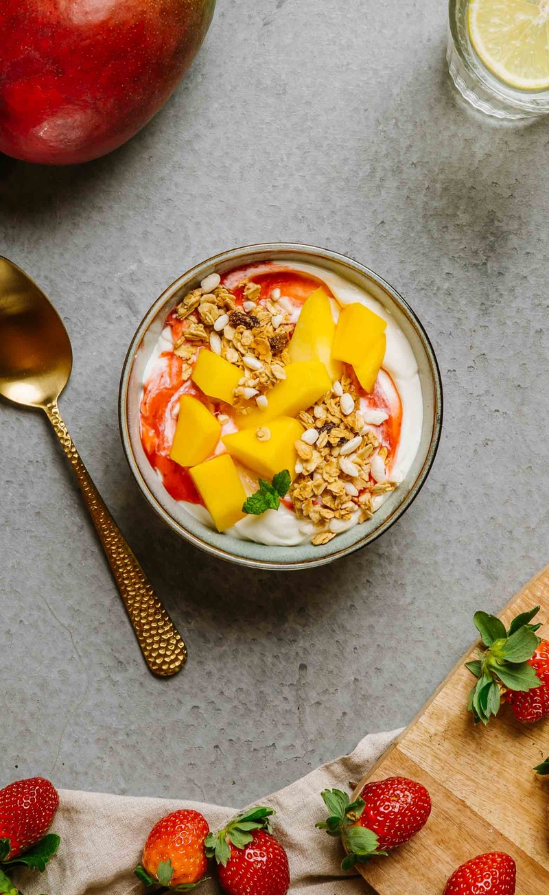 Granola z preparowanym ryżem i rodzynkami, jogurt kokosowy, mus truskawkowy, mango