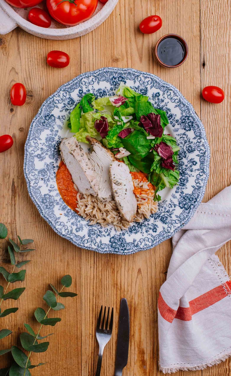 Pełnoziarniste orzo w sosie pomidorowym z pikantną 'ndują, plastry kurczaka, sałatka z dressingiem balsamico