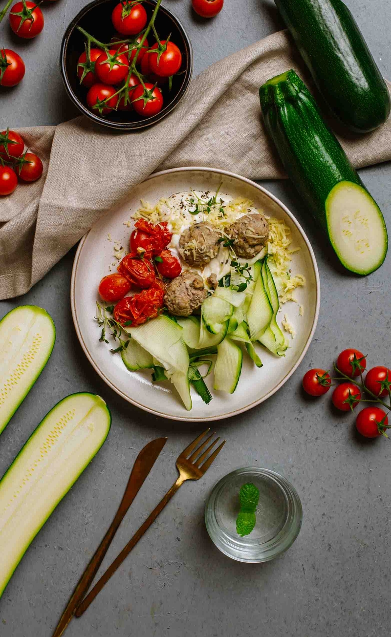 Keto meatballs w sosie serowym z cheddarem, makaron z cukinii, pieczone pomidorki w maśle