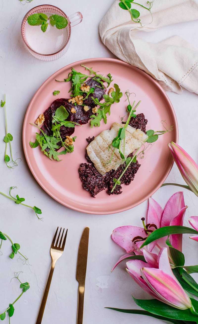 Filet halibuta na czarnym risotto z kiełkami groszku, carpaccio z buraków z orzechami i rukolą