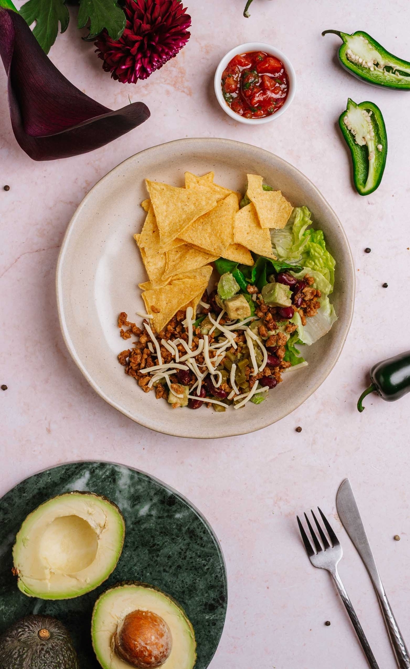 Taco bowl z roślinnym mięsem, czerwoną fasolą, awokado, serem cheddar i jalapeno, pomidorowa salsa z kolendrą, kukurydziane nachosy