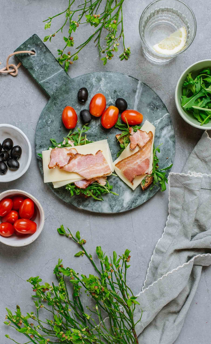 Keto kanapka z keczonezem, żółtym serem, bekonem i rukolą, pomidorki daktylowe z czarnymi oliwkami