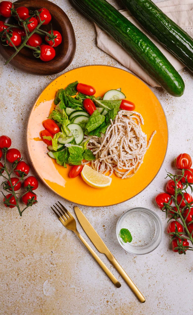 Razowe spaghetti cacio e pepe, sałata rzymska z pomidorkami i świeżym ogórkiem