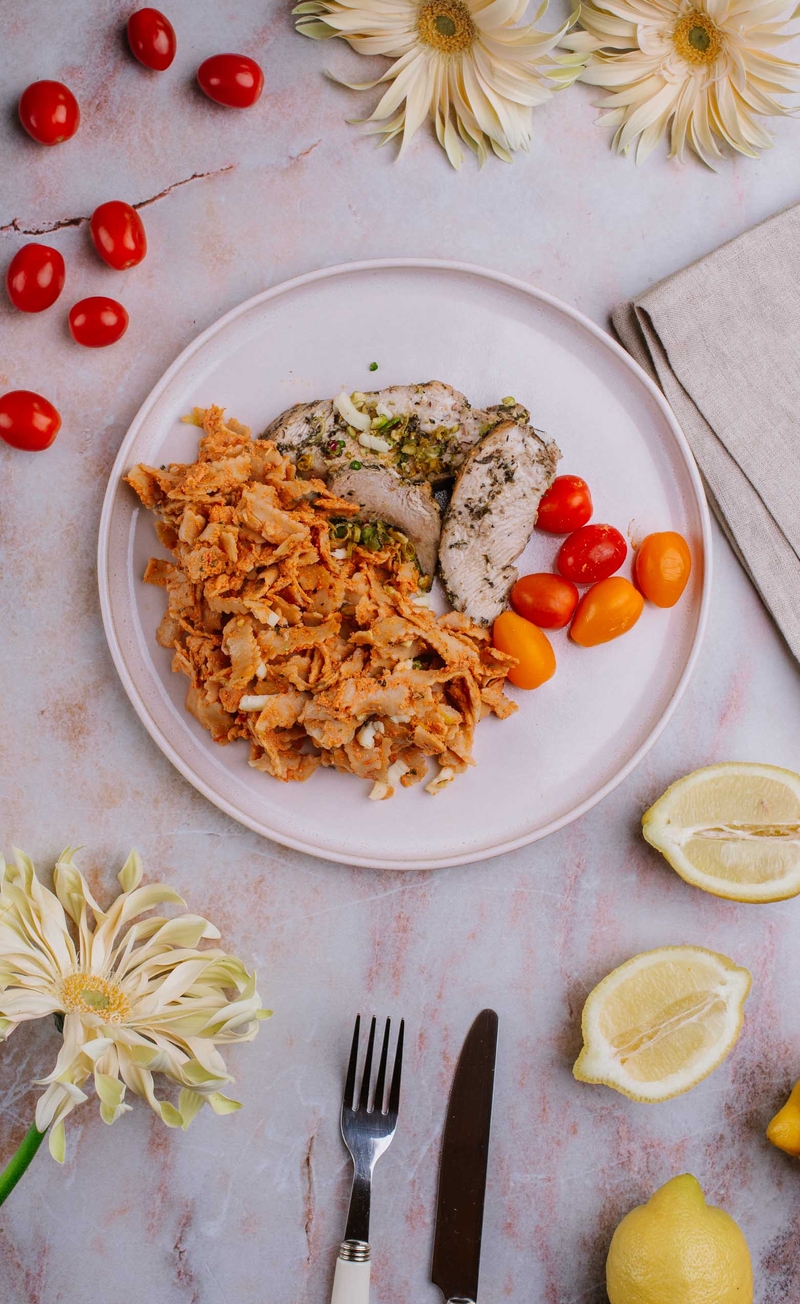 Plastry indyka na pełnoziarnistym tagliatelle w sosie z mozzarellą fior di latte, czosnkiem niedźwiedzim, pistacjami i zestem z cytryny, świeże warzywa
