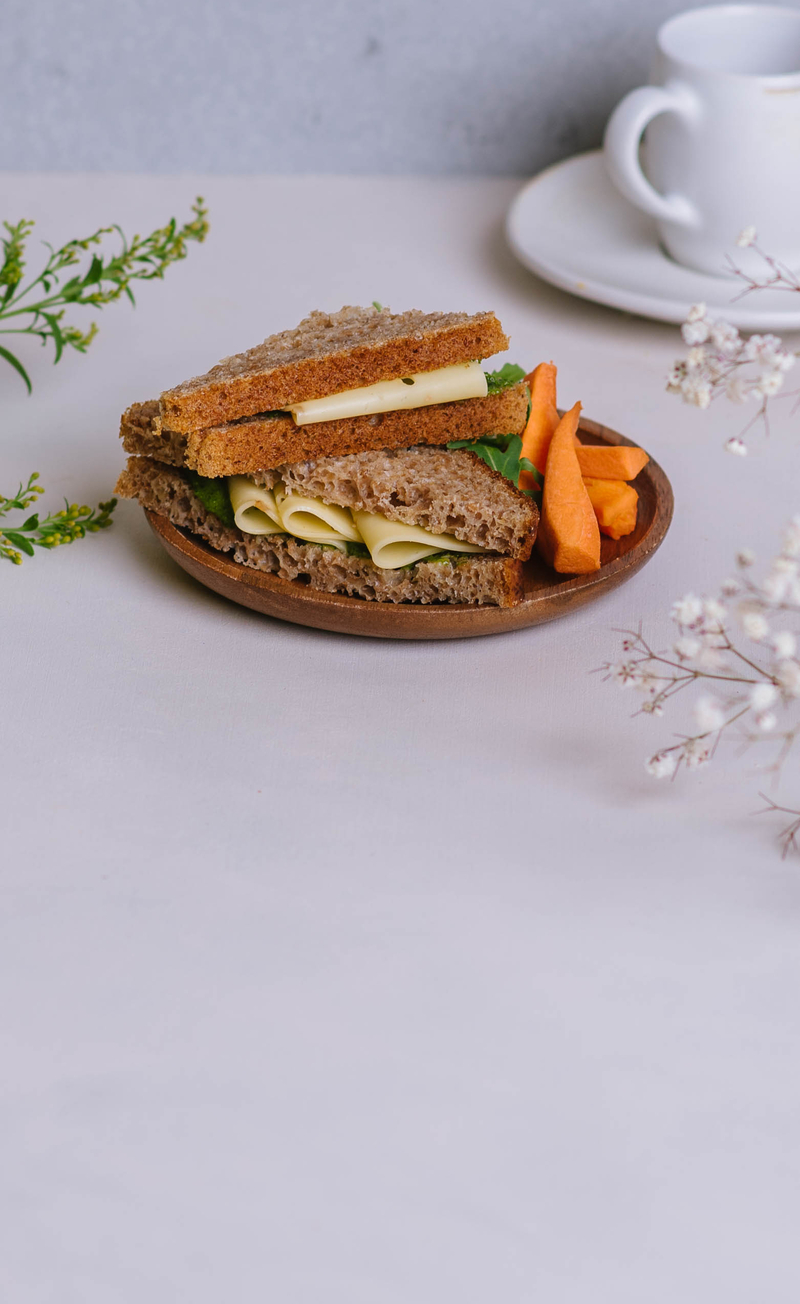 Kanapka razowa z pesto z rukoli i żółtym serem, słupki marchewki