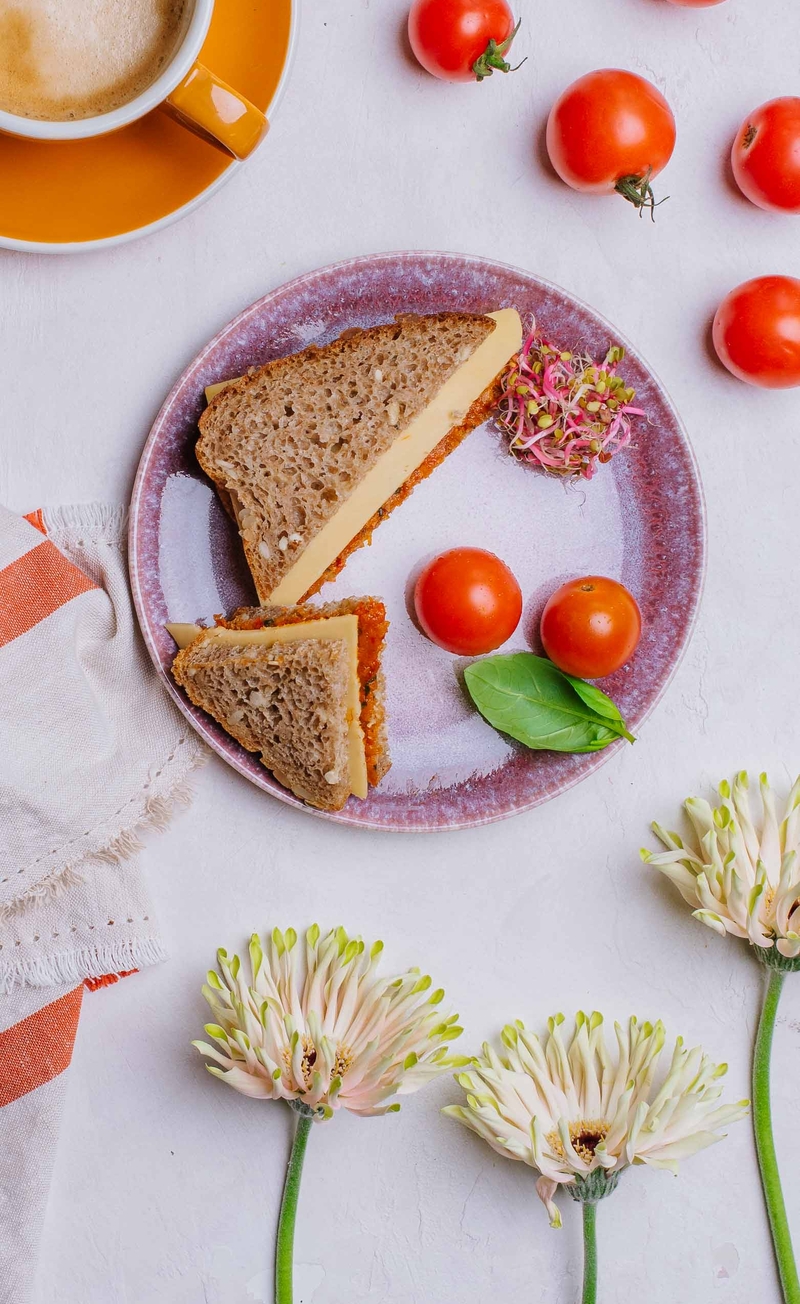 Kanapka razowa z pastą z pieczonej papryki i serem cheddar, pomidorki