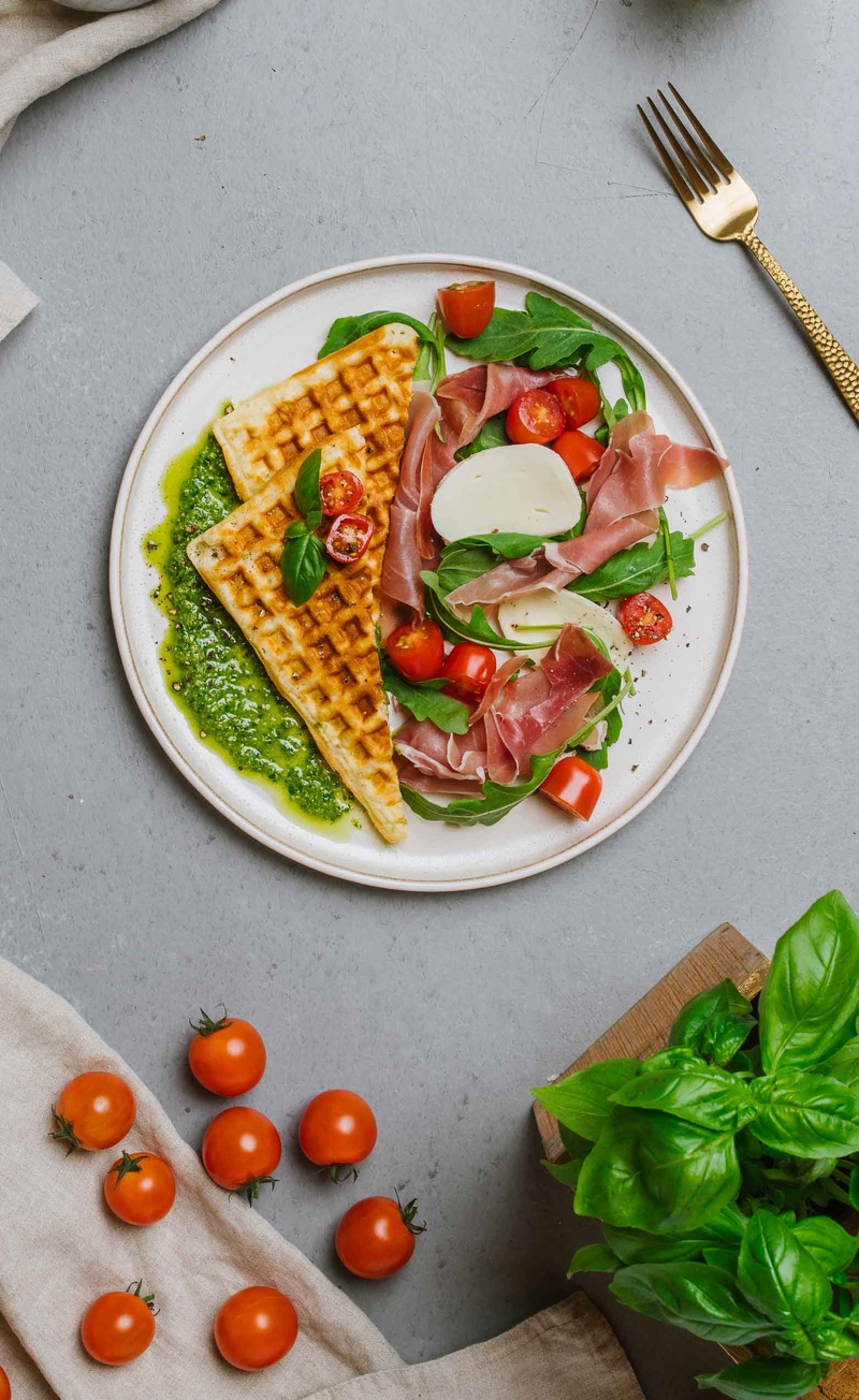 Gofry z pesto bazyliowym, szynką parmeńską, mozzarellą i rukolą, pomidorki