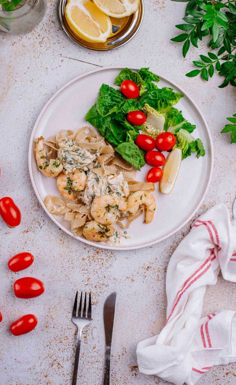Pełnoziarniste tagliatelle z krewetkami w sosie z papryczką chilli i natką pietruszki, świeże warzywa z cząstką cytryny