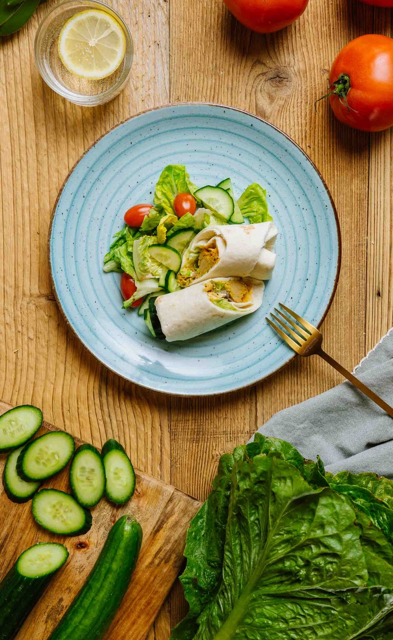 Gyros z wegańskim kurczakiem, czerwoną cebulą i dipem tzatziki, sałata rzymska z ogórkiem i pomidorkami