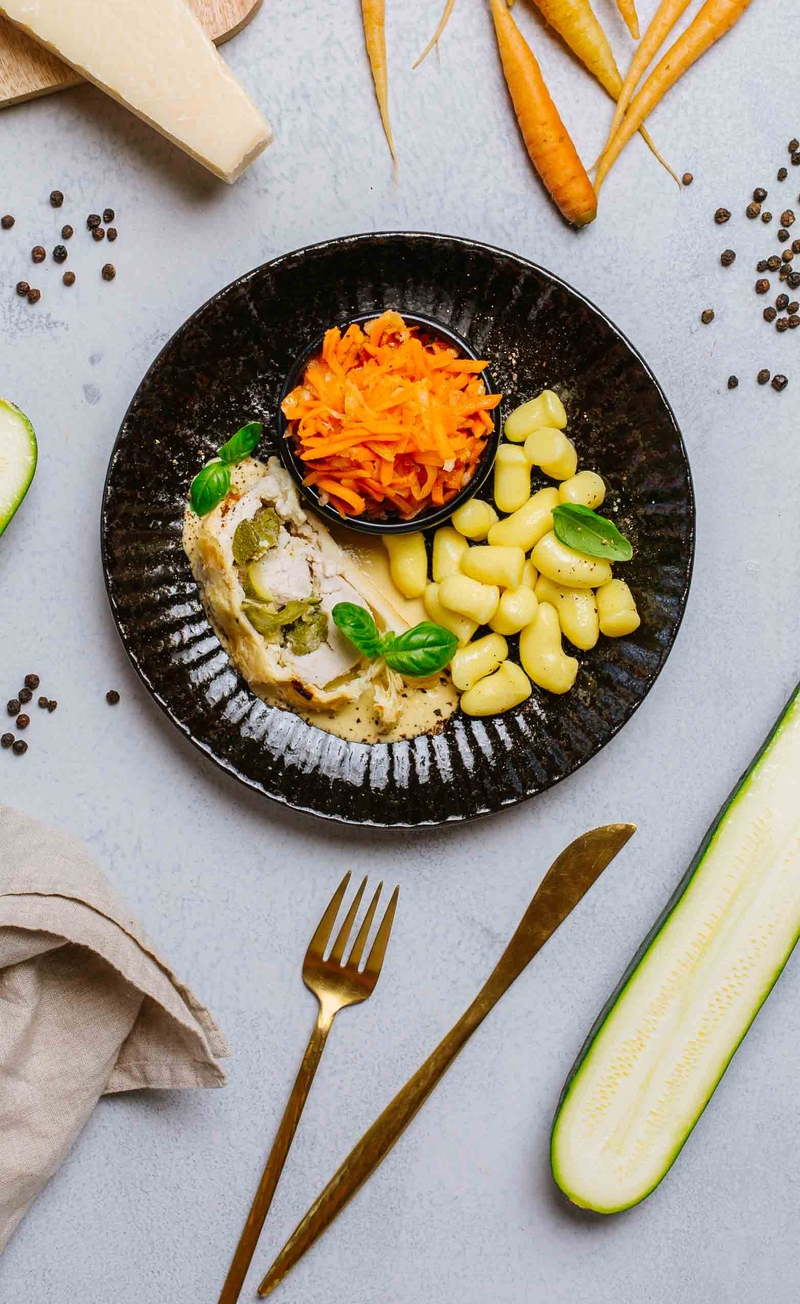 Roladka z indyka w cieście francuskim ze szparagami, cukinią i parmezanem, sos śmietankowy, kopytka, surówka marchewkowa