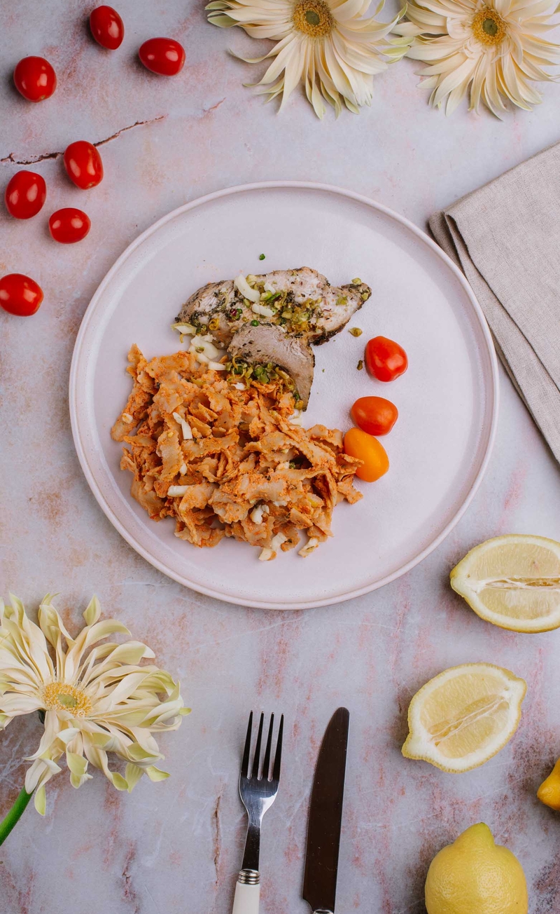 Plastry indyka na pełnoziarnistym tagliatelle w sosie z mozzarellą fior di latte, czosnkiem niedźwiedzim, pistacjami i zestem z cytryny, świeże warzywa