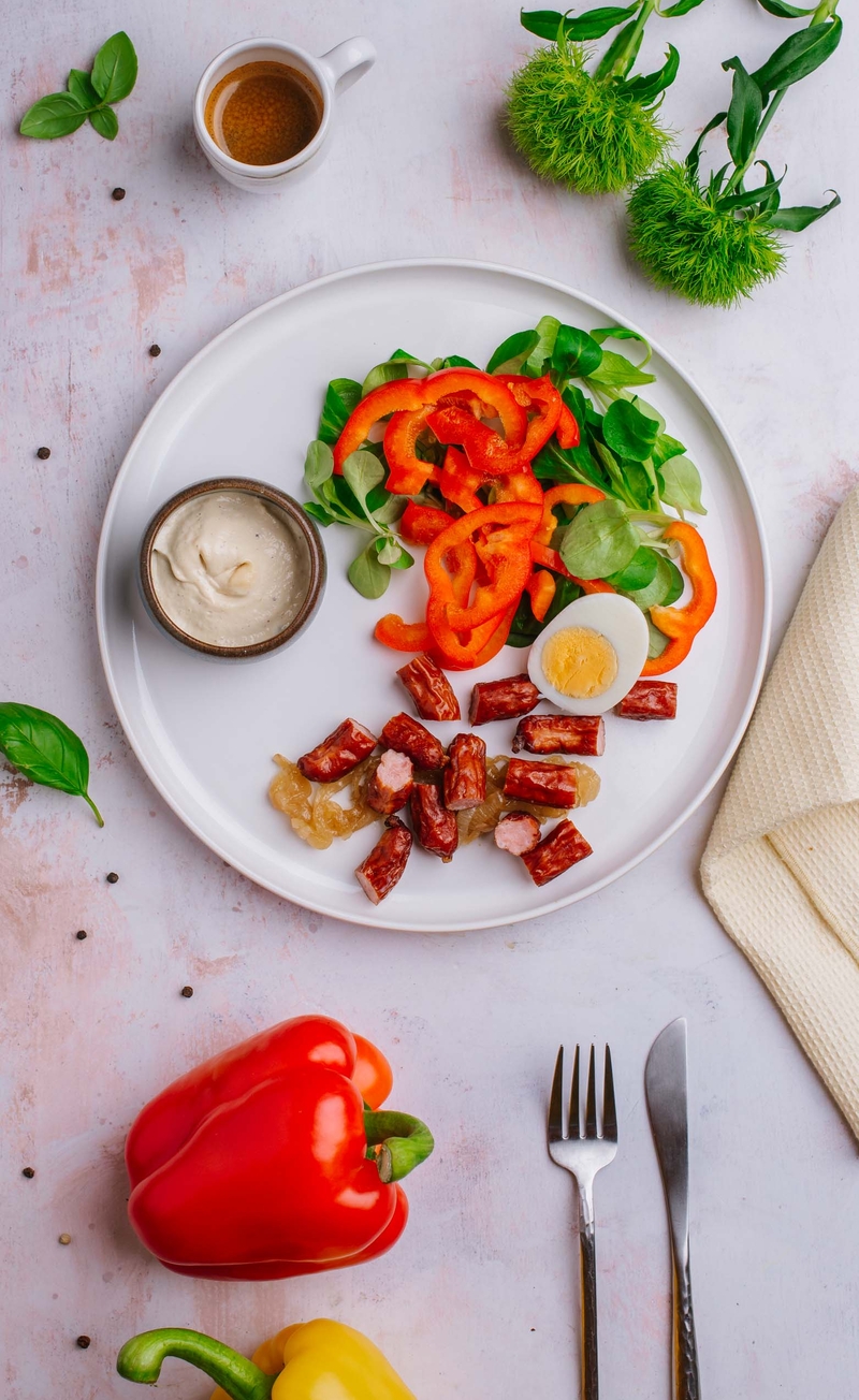 Keto frankfurterki z pieczoną cebulą i jajkiem, sos musztardowy, świeże warzywa