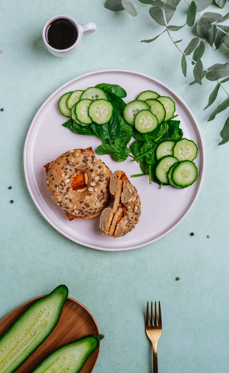 Bajgiel z wędzonym tofu i serkiem sriracha, świeży ogórek