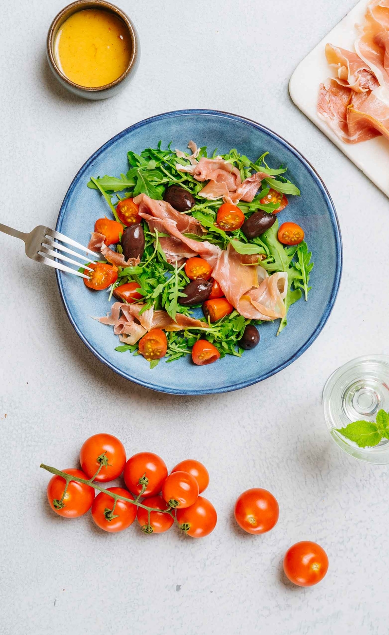 Sałatka z szynką serrano, oliwkami kalamata i rukolą, pikantny dressing z chilli