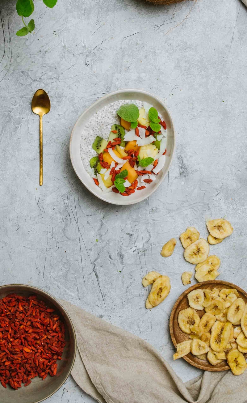 Pudding chia z tapioką, mlekiem kokosowym, chipsami bananowymi i jagodami goji, owoce tropikalne