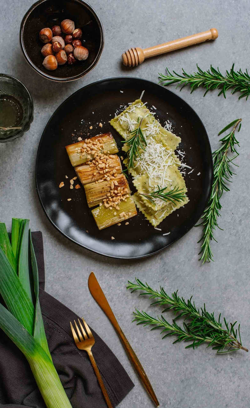 Ravioli z kurkami w ziołowym cieście z Pecorino Romano, pieczone pory z miodem i orzechami laskowymi