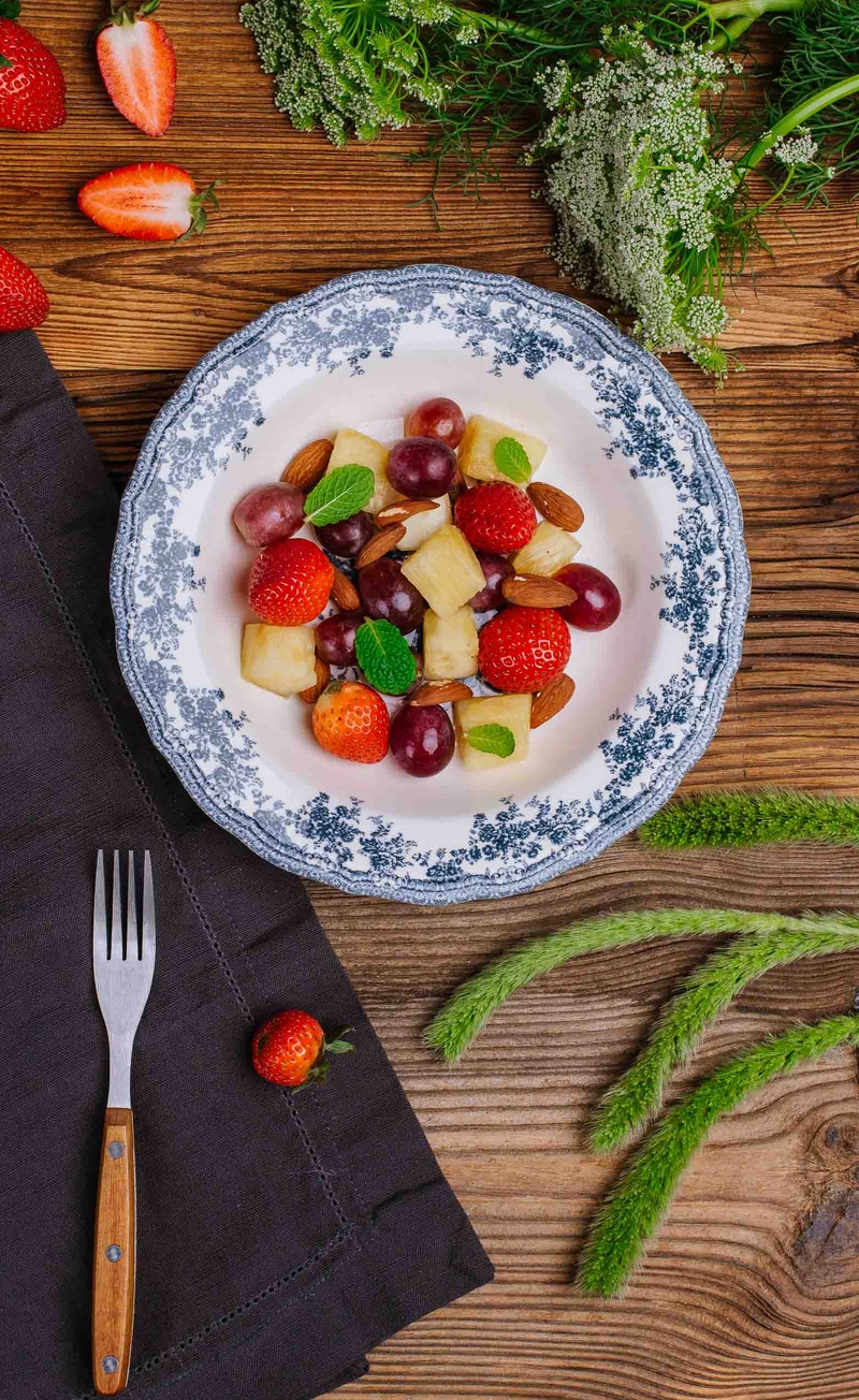 Miska świeżych owoców: ananas, winogrona, truskawki, migdały