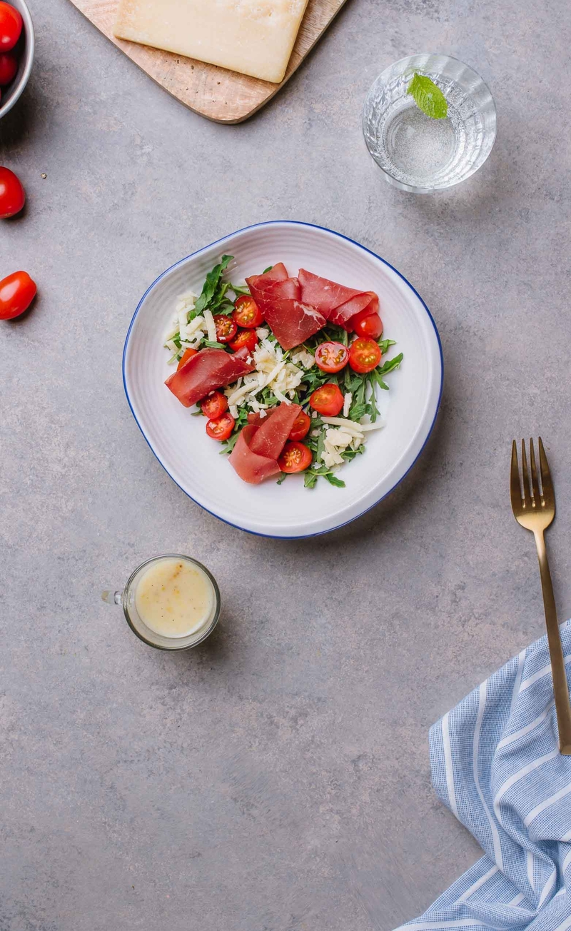Sałatka z rukolą, szynką bresaola, serem grana padano, pomidorki koktajlowe, sos winegret
