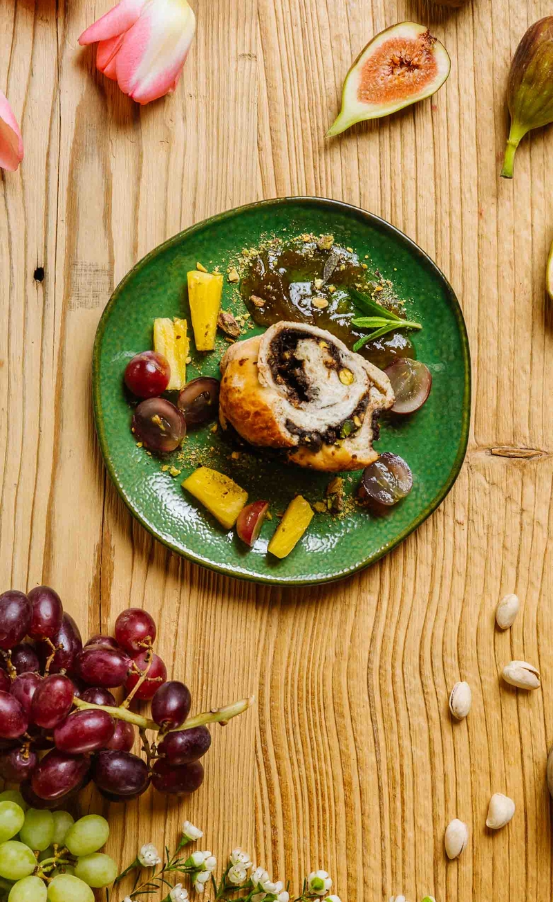 Drożdżowa rolada z mocno czekoladowym kremem z pistacjami, konfitura figowa, winogrona, ananas