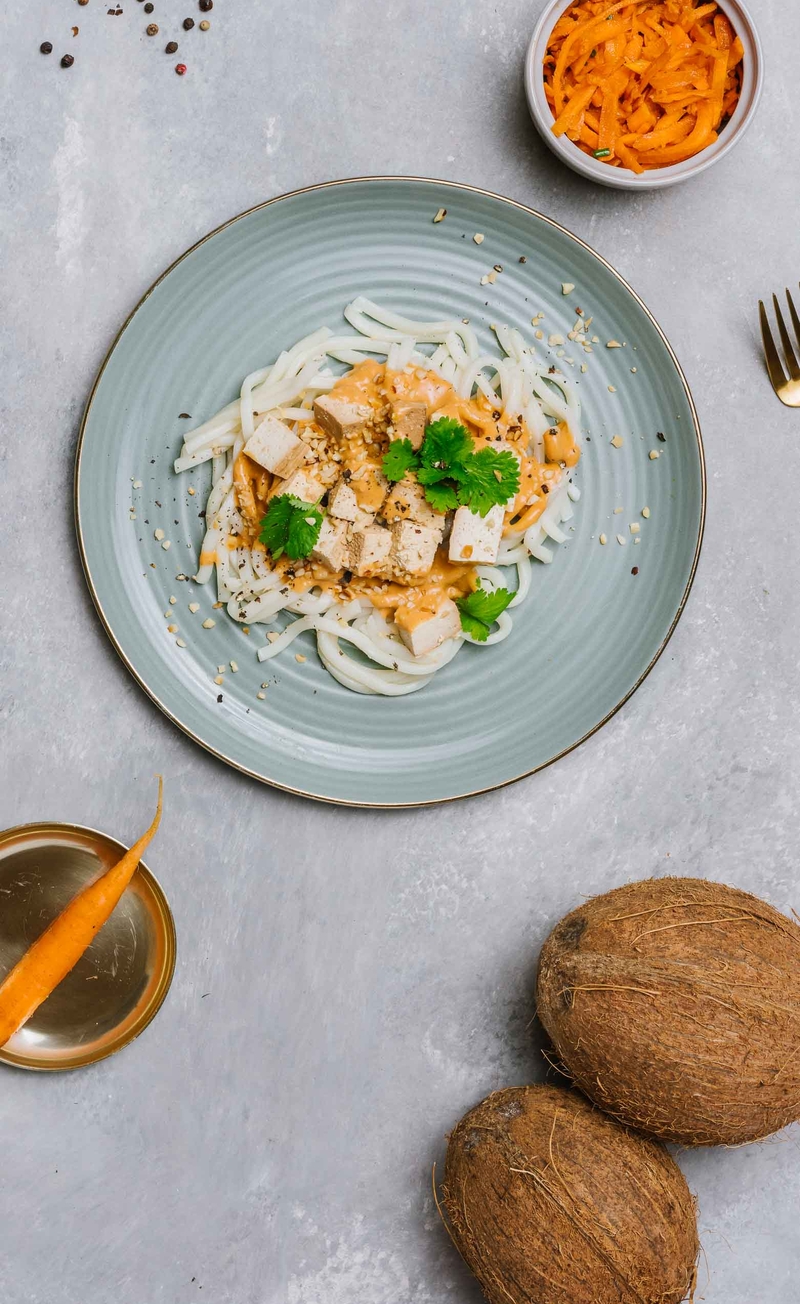 Makaron udon w pikantnym sosie kokosowo-orzechowym z pomidorami i tofu wędzonym, surówka z marchewki po koreańsku