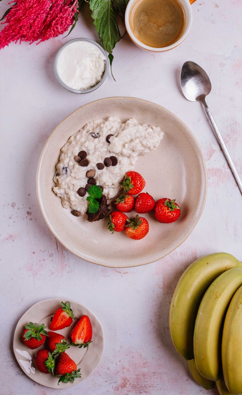 Proteinowa owsianka banoffee z gorzką czekoladą, bita śmietana bez cukru, truskawki