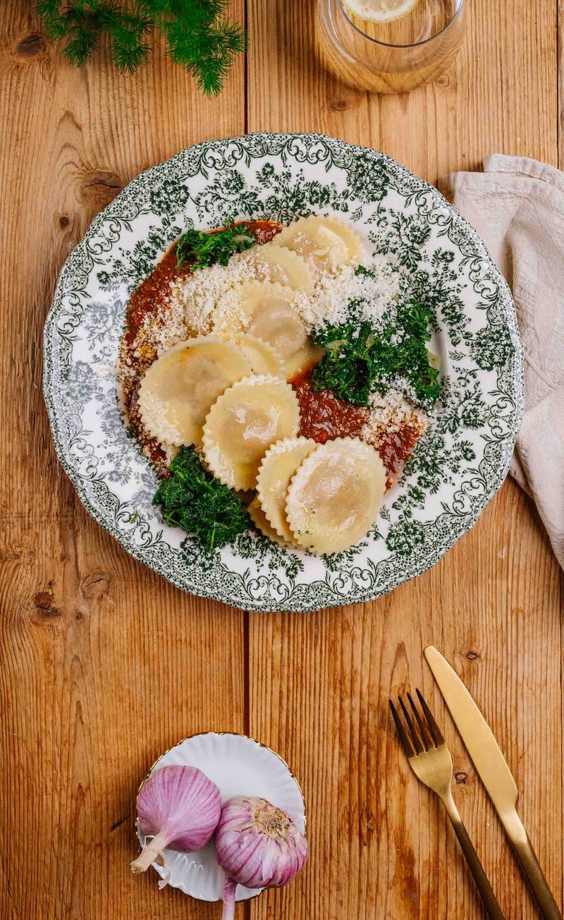 Tortellini z pomidorami i mozzarellą w sosie z dodatkiem pesto genovese, blanszowany szpinak z czosnkiem i gałką muszkatołową