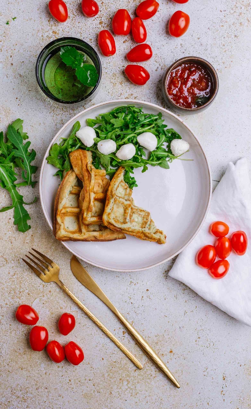 Gofry bazyliowe z mozzarellą i rukolą, pomidory z kremem balsamicznym i oliwą